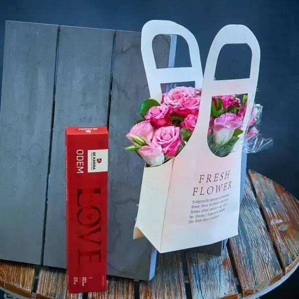 Romantic surprise package combining bouquet of roses and pralines